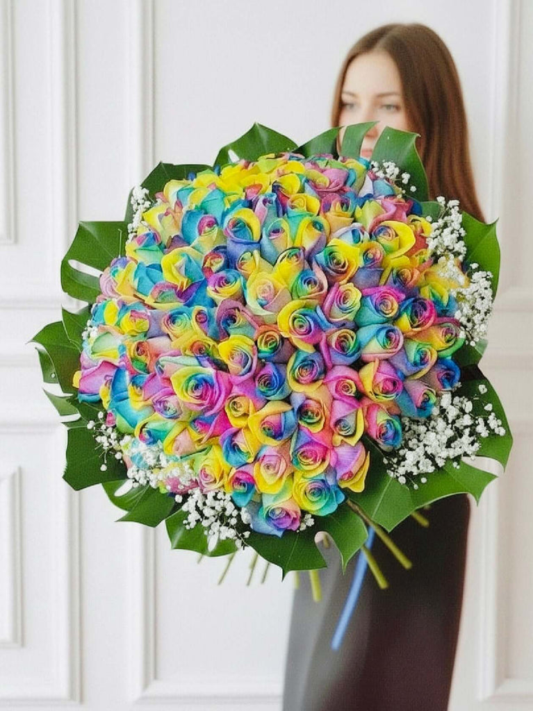 100 Bouquet of colourful rainbow roses held by a woman against a white background