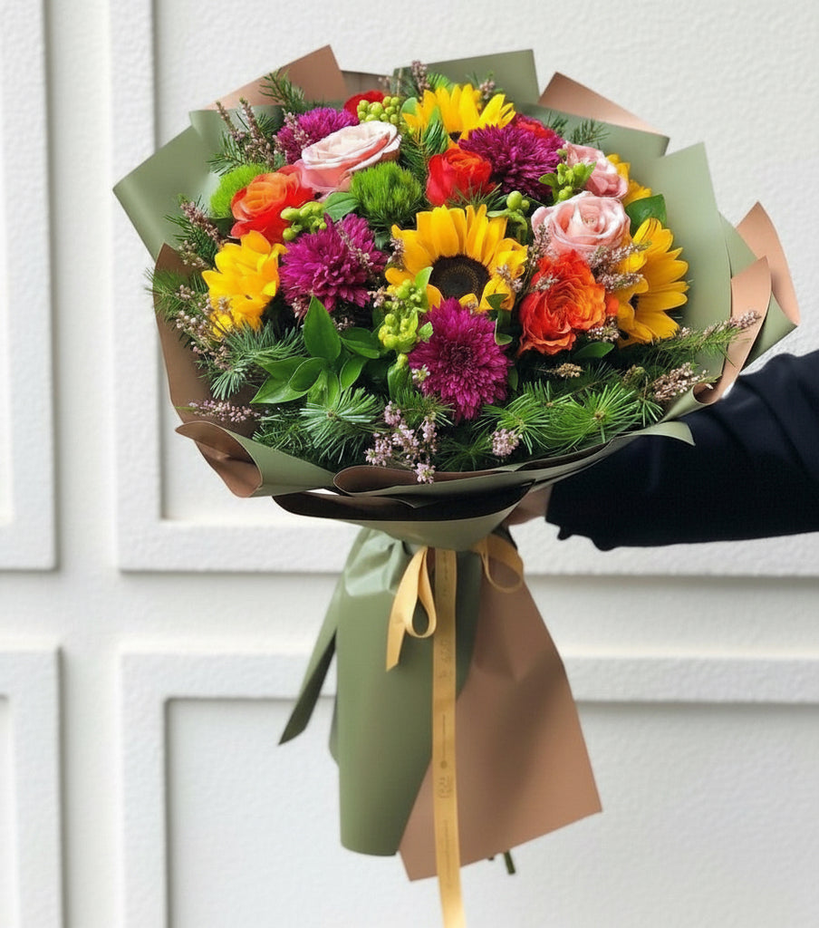 Bouquet of colorful flowers held by a person outdoors